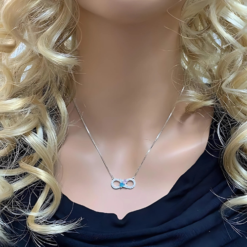 Detail of the two gemstones and infinity symbol.